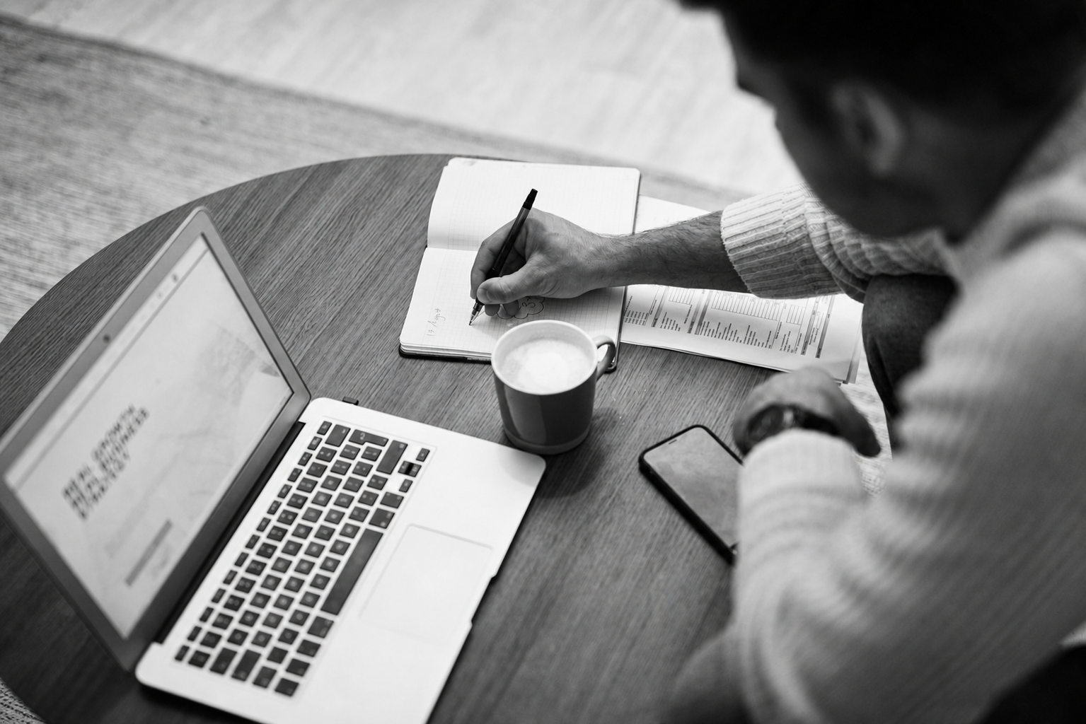 A non-technical founder taking notes while reviewing agency portfolios and Clutch reviews