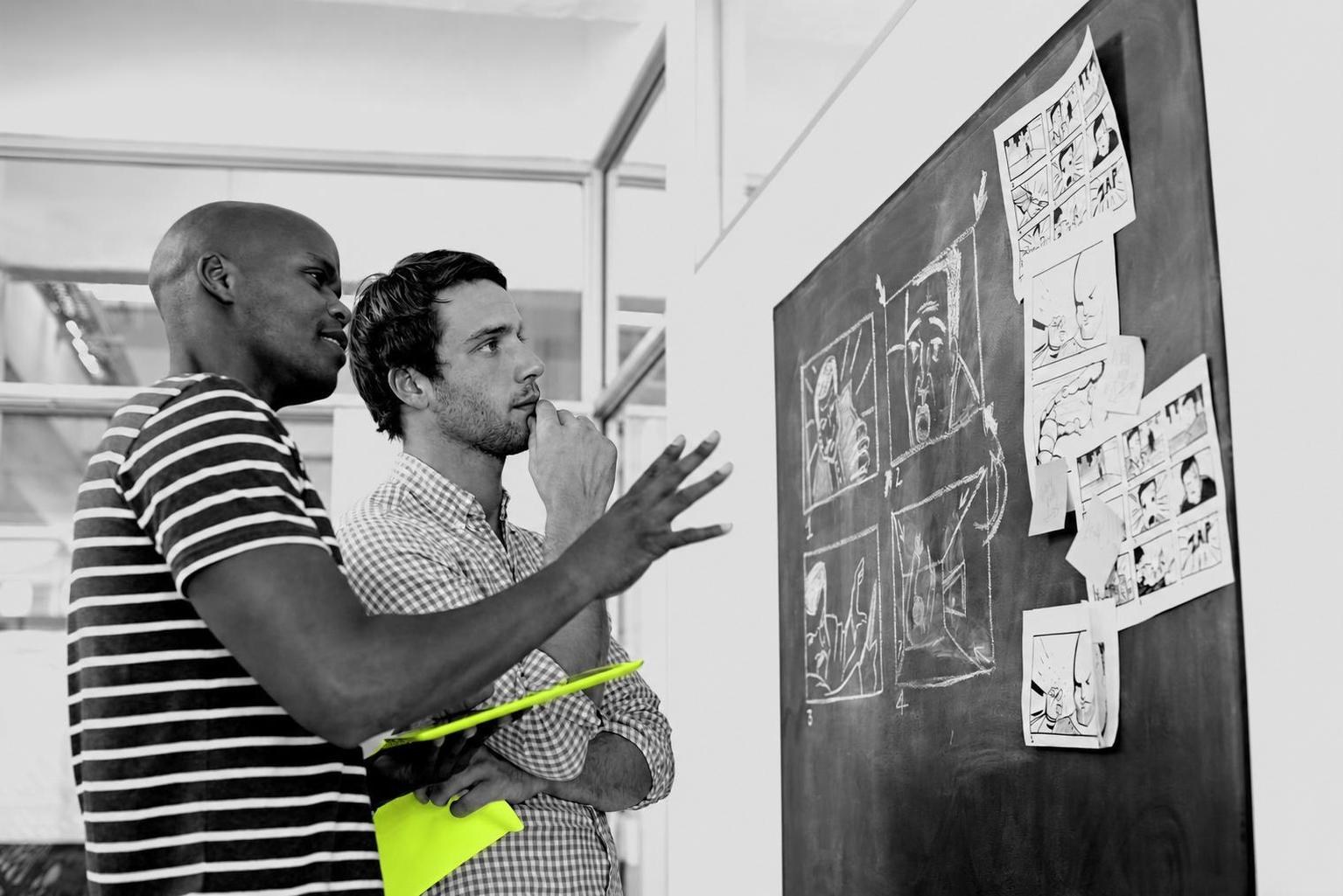A founder and two teammates brainstorming a startup build at a desk