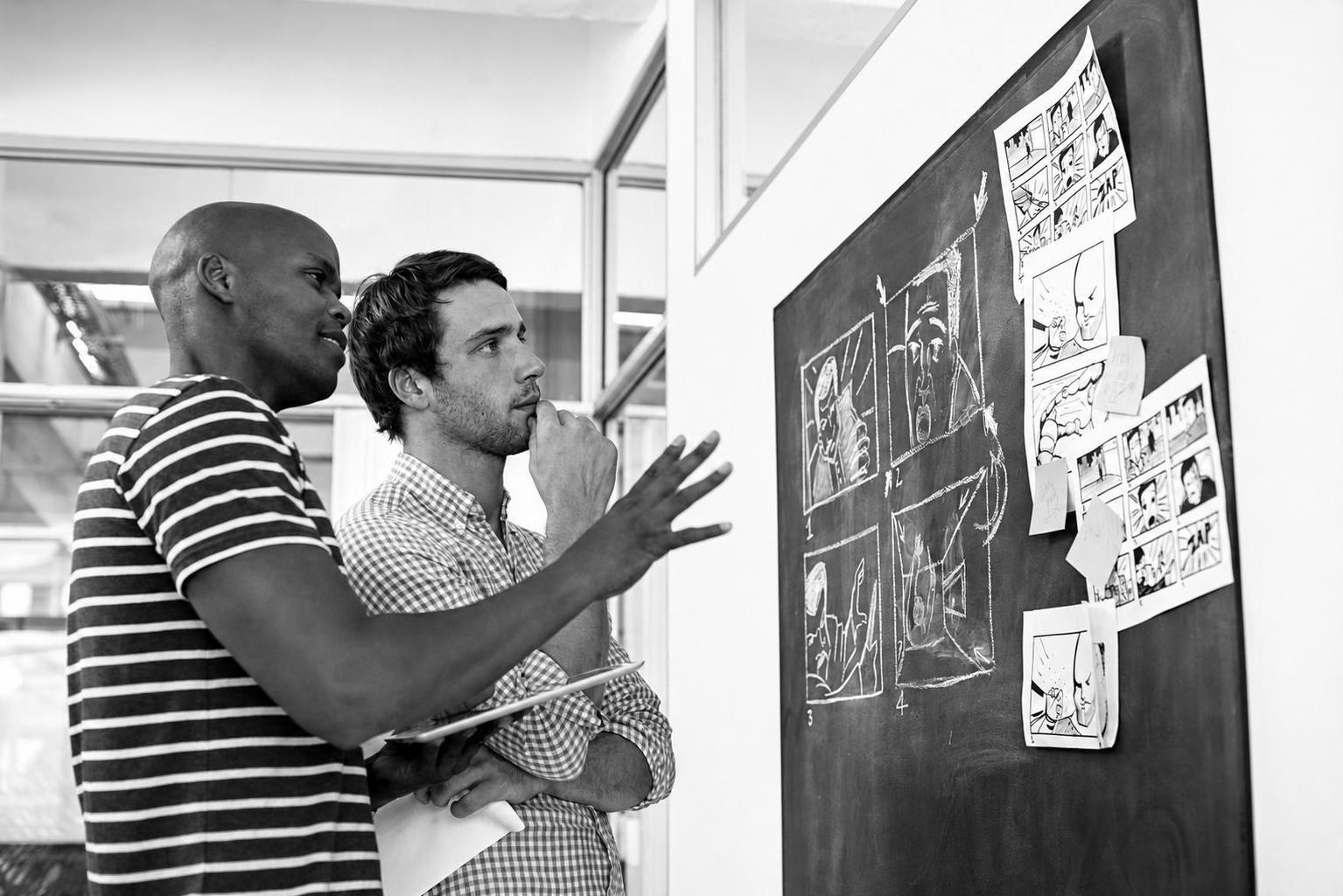 A founder reviewing a product scope document and user flow diagrams with a development team