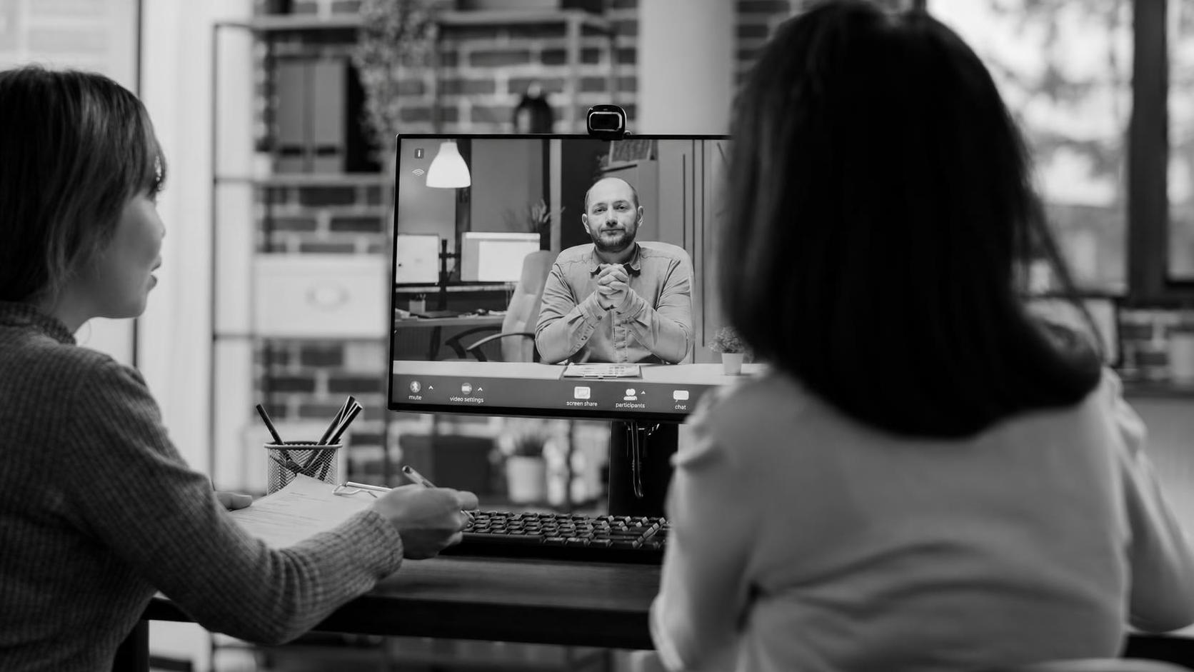 A founder evaluating a build team over a video call, notes in hand