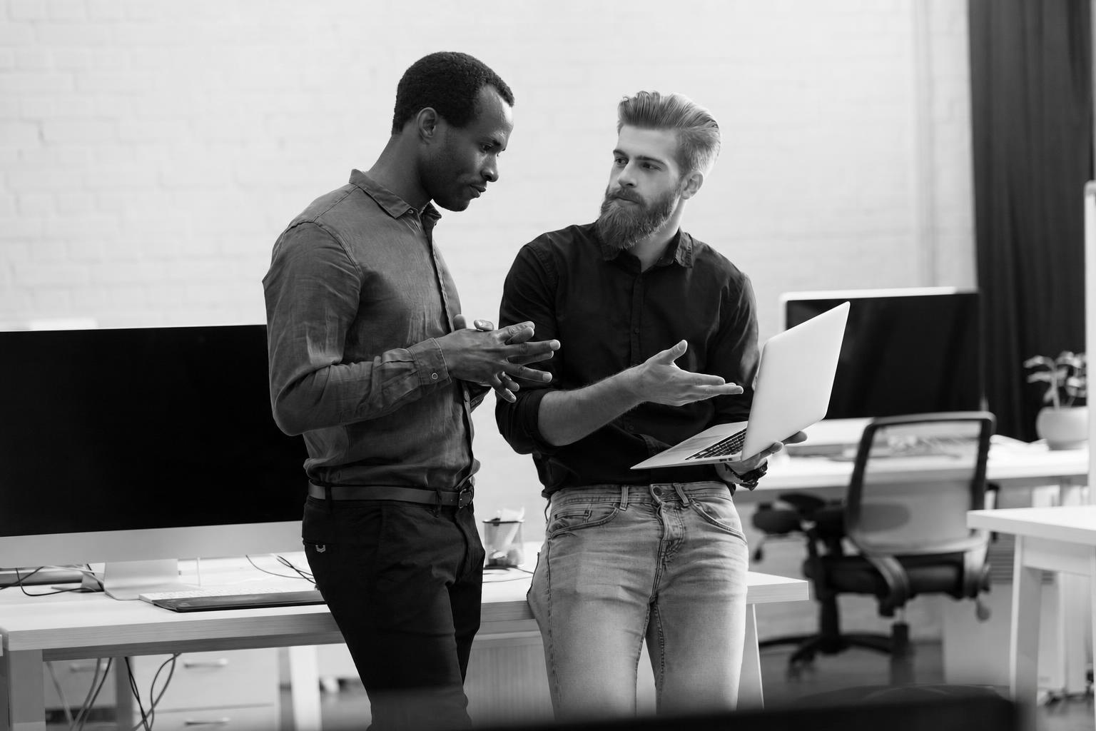 A founder and developer reviewing a booking flow on a laptop during a sprint review