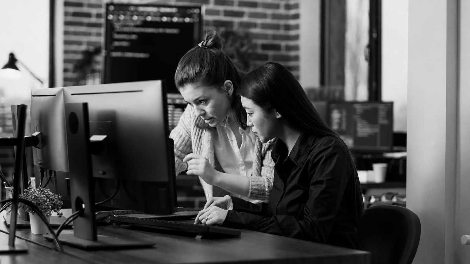 A developer and a founder reviewing a codebase together on a large monitor
