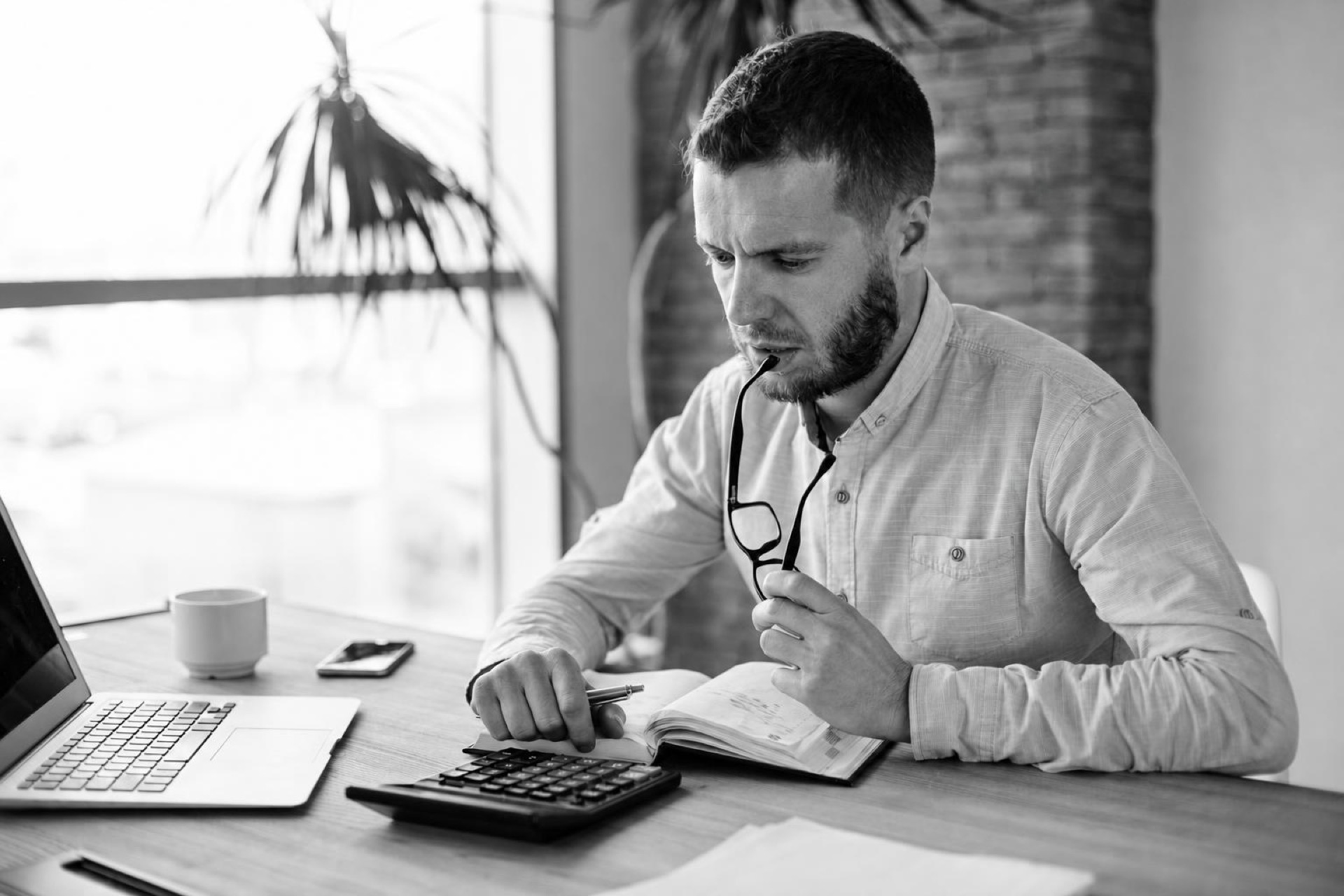 A founder reviewing a monthly budget spreadsheet with team salary and hosting costs