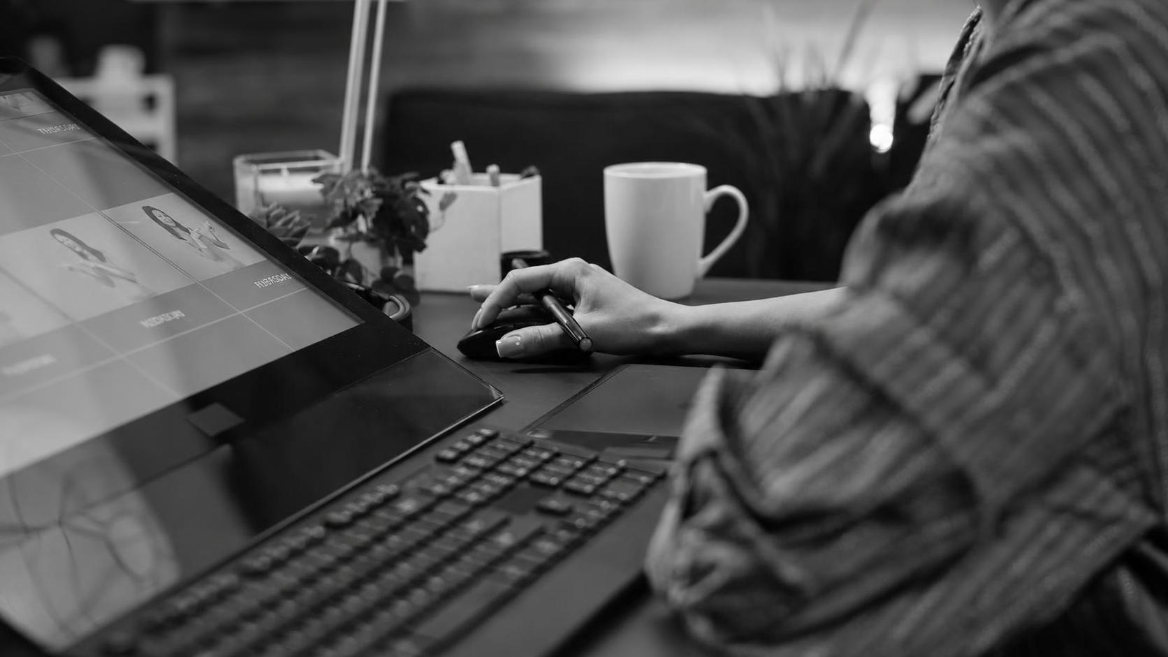 A hand carefully retouching fine details on a screen