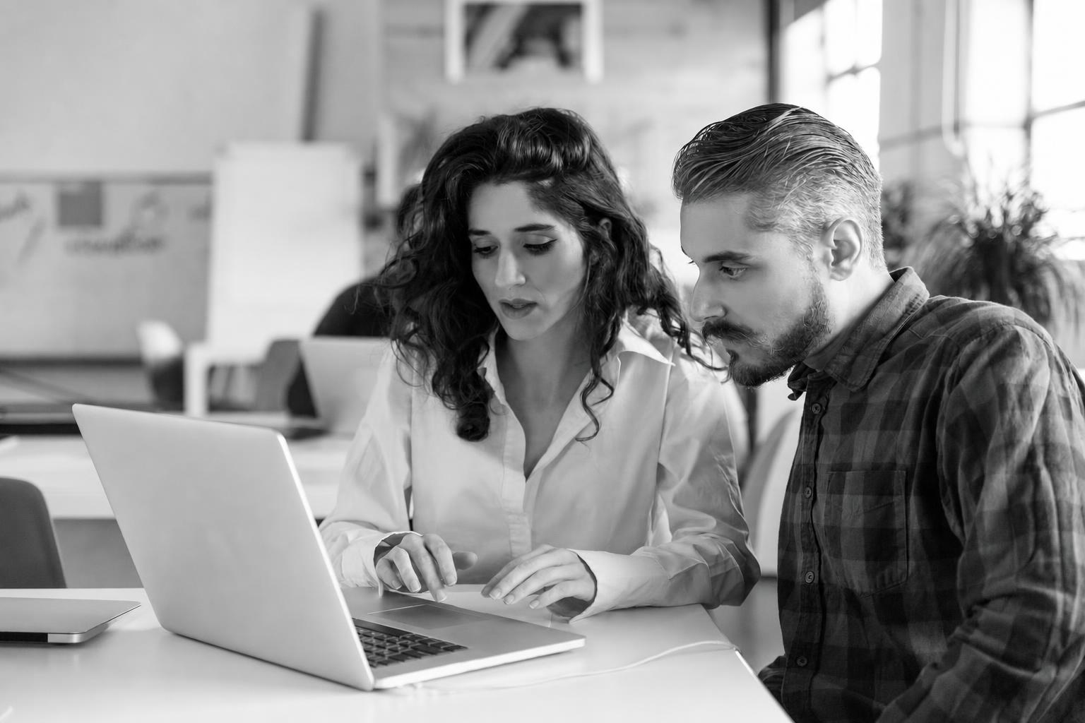 A founder and developer reviewing a cost and timeline breakdown on a laptop